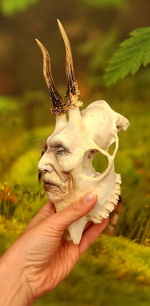Side view of Honouring Death spirit skull sculpture showing human face emerging from skull form
