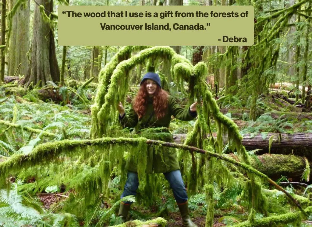 Debra standing in a lush green forest with a quote about Vancouver Island wood.
