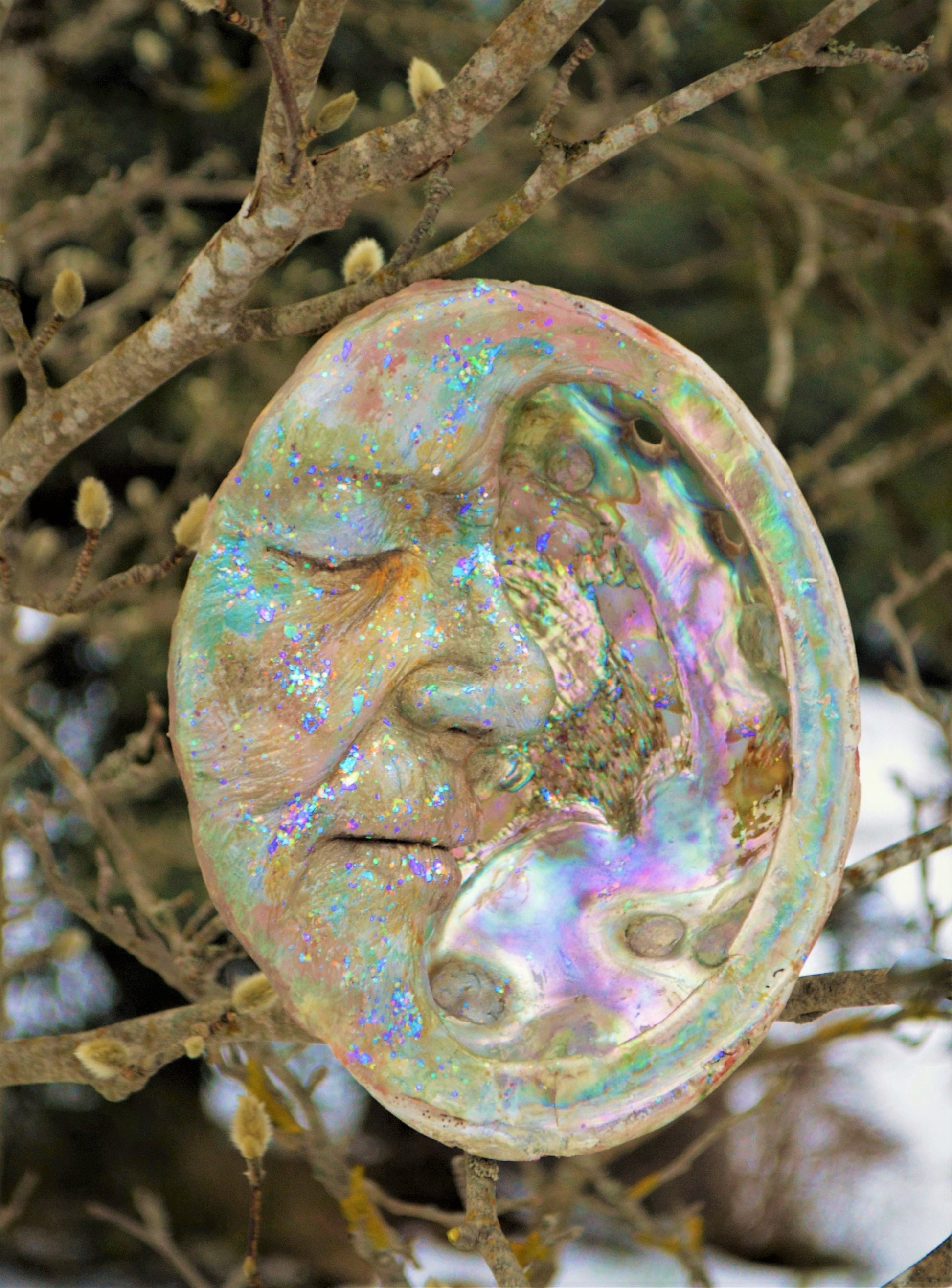 Side view of Moon Keeper abalone moon sculpture showing curved moon form and shell inlay