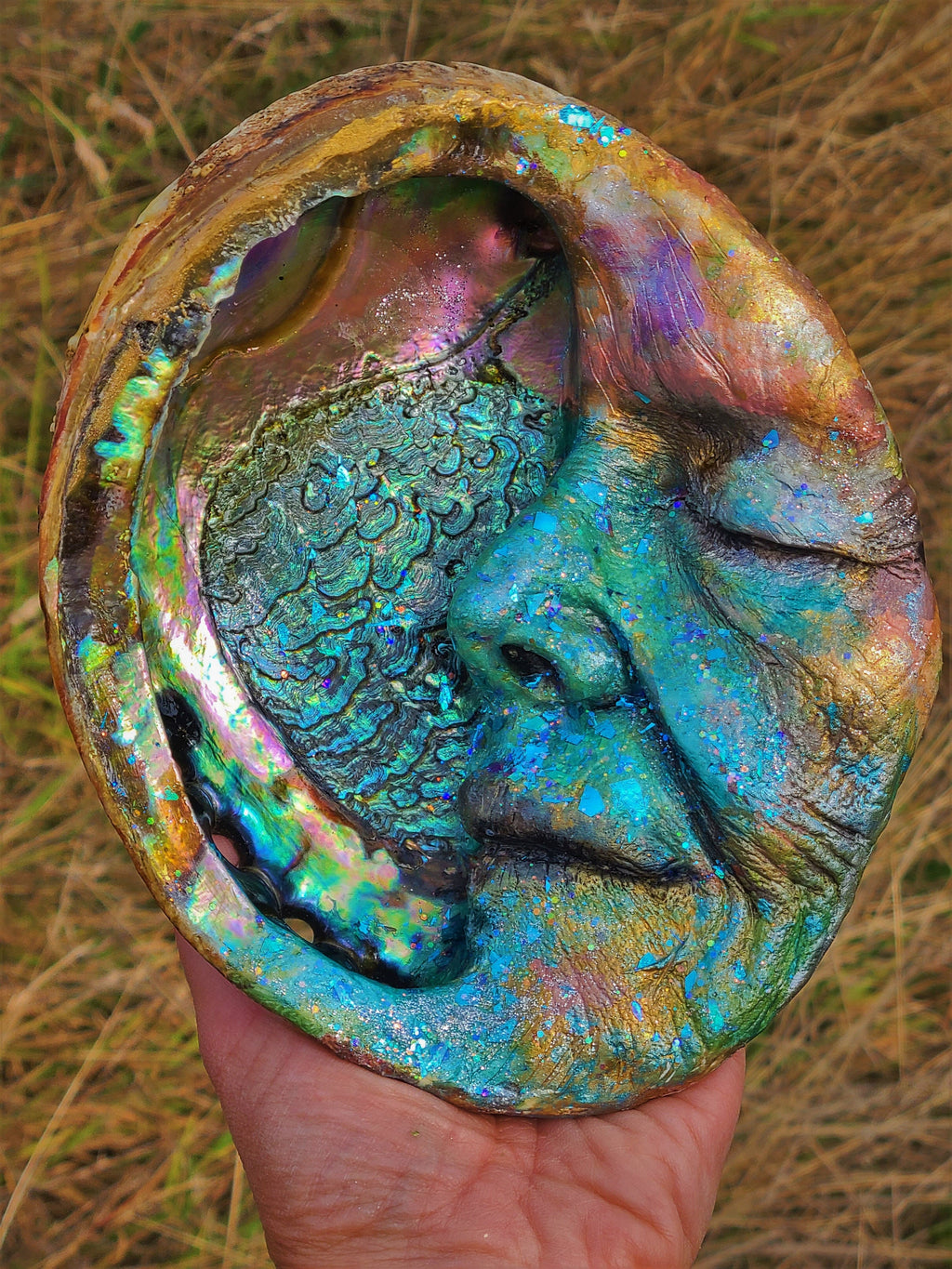 Close up of abalone shell inlay on Moon Keeper moon sculpture with iridescent texture detail