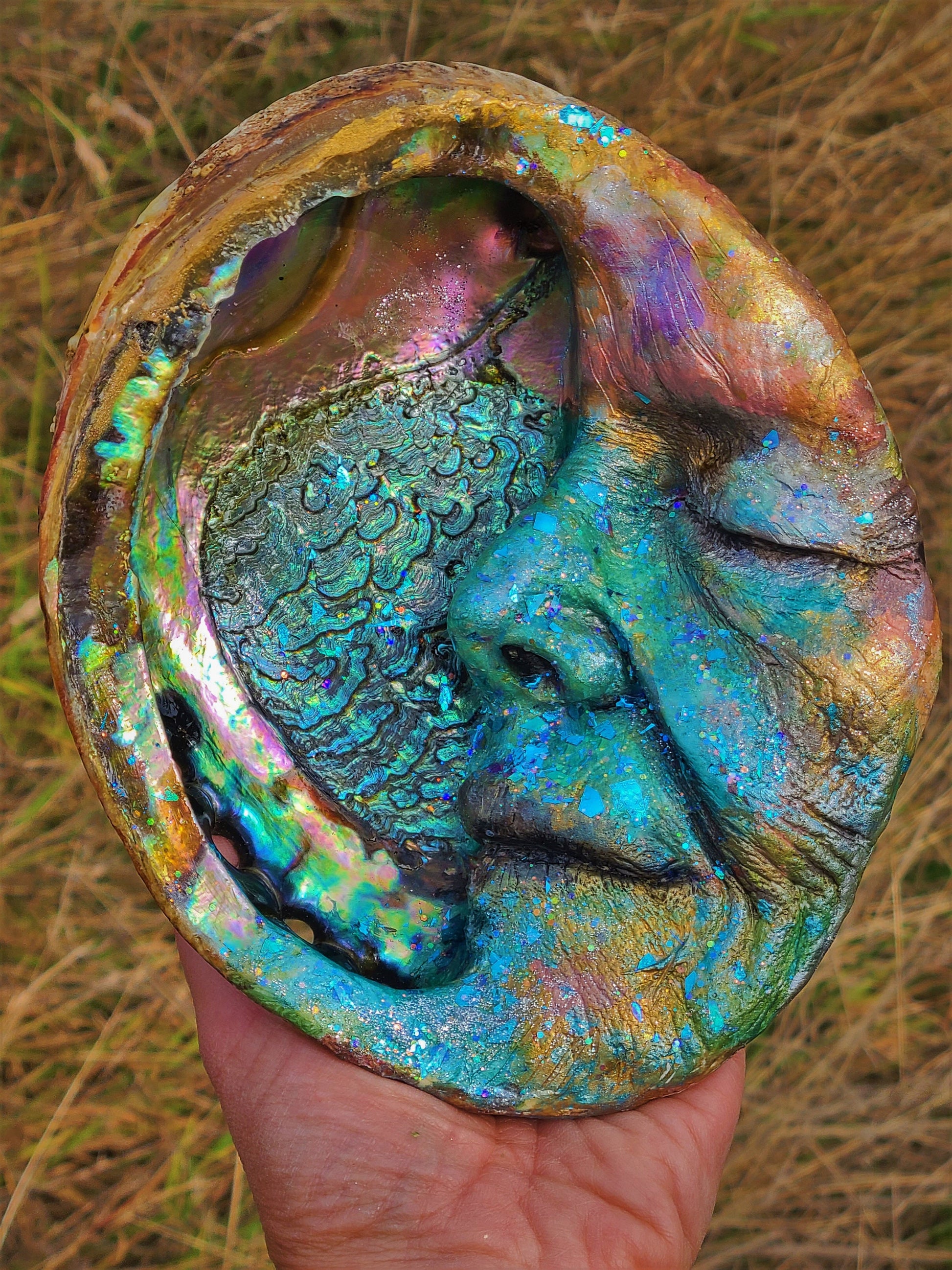 Close up of abalone shell inlay on Moon Keeper moon sculpture with iridescent texture detail
