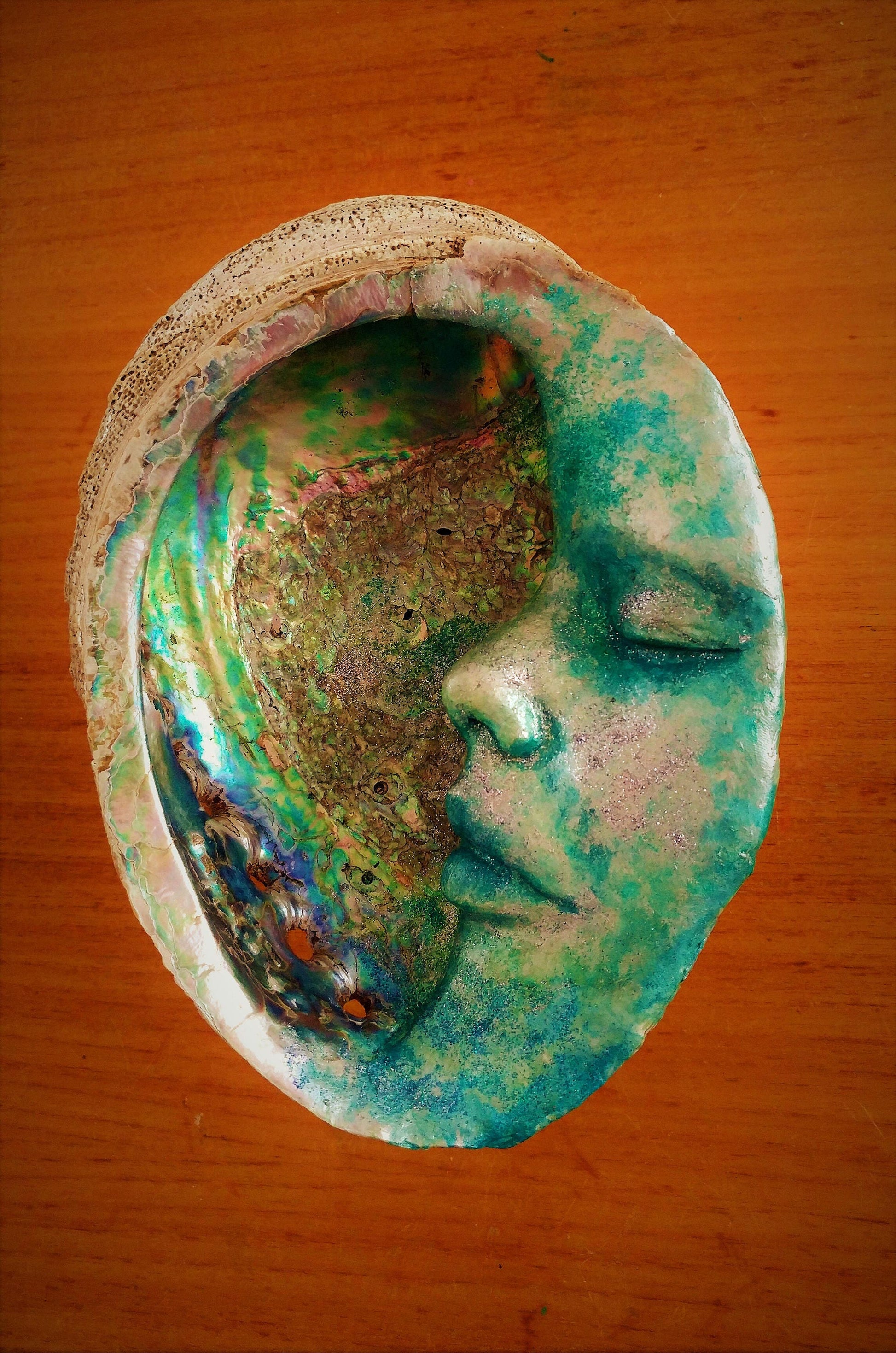 Close up of abalone shell inlay on Moon of New Beginnings moon sculpture with iridescent texture detail